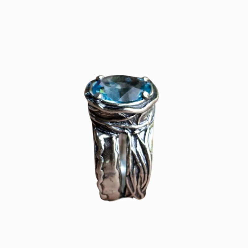 Silver Ring - artisan-crafted in .925 sterling silver with a faceted blue topaz; an alternative side view is shown on a white background. 
