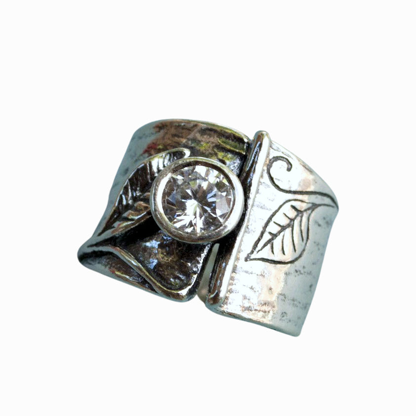 Sterling silver ring with leaf designs and a bezel set round cut clear CZ.