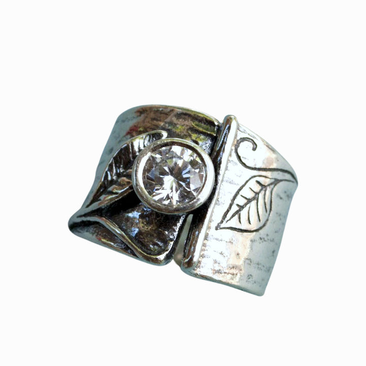 Sterling silver ring with leaf designs and a bezel set round cut clear CZ.