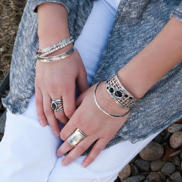 Silver and Black Stone Ring- artisan-crafted of .925 sterling silver and a cabachon of black onyx. The stone is pear shaped. Shown on a model.