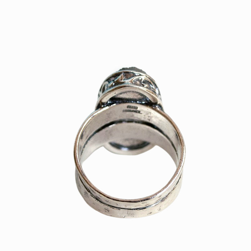 A sterling silver ring with a central oval-shaped druzy quartz stone, featuring a double-hammered band and a comfort fit design. A back view is shown on a white background.