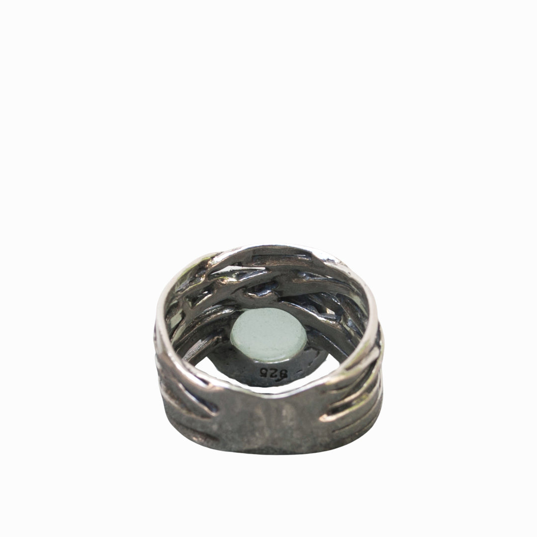 A sterling silver ring with a faceted aqua chalcedony dome on a chunky band, displayed from the back with the .925 stamp of quality shown. 