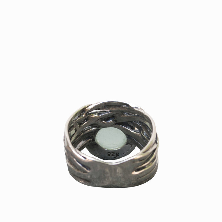 A sterling silver ring with a faceted aqua chalcedony dome on a chunky band, displayed from the back with the .925 stamp of quality shown. 