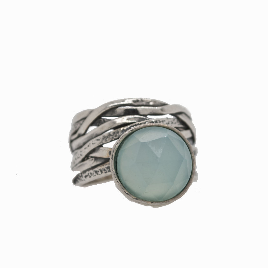 A sterling silver ring with a faceted aqua chalcedony dome on a chunky band, displayed on a white background. 