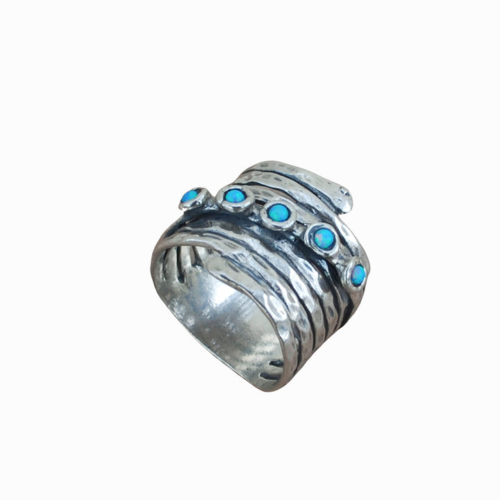 An artisan-crafted hammered sterling silver ring with opal accents is shown on a white background.