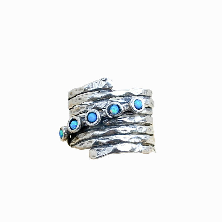 An artisan-crafted hammered sterling silver ring with opal accents is shown on a white background.