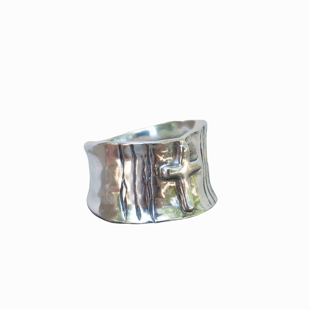 A silver band ring with a cross design on a white background.