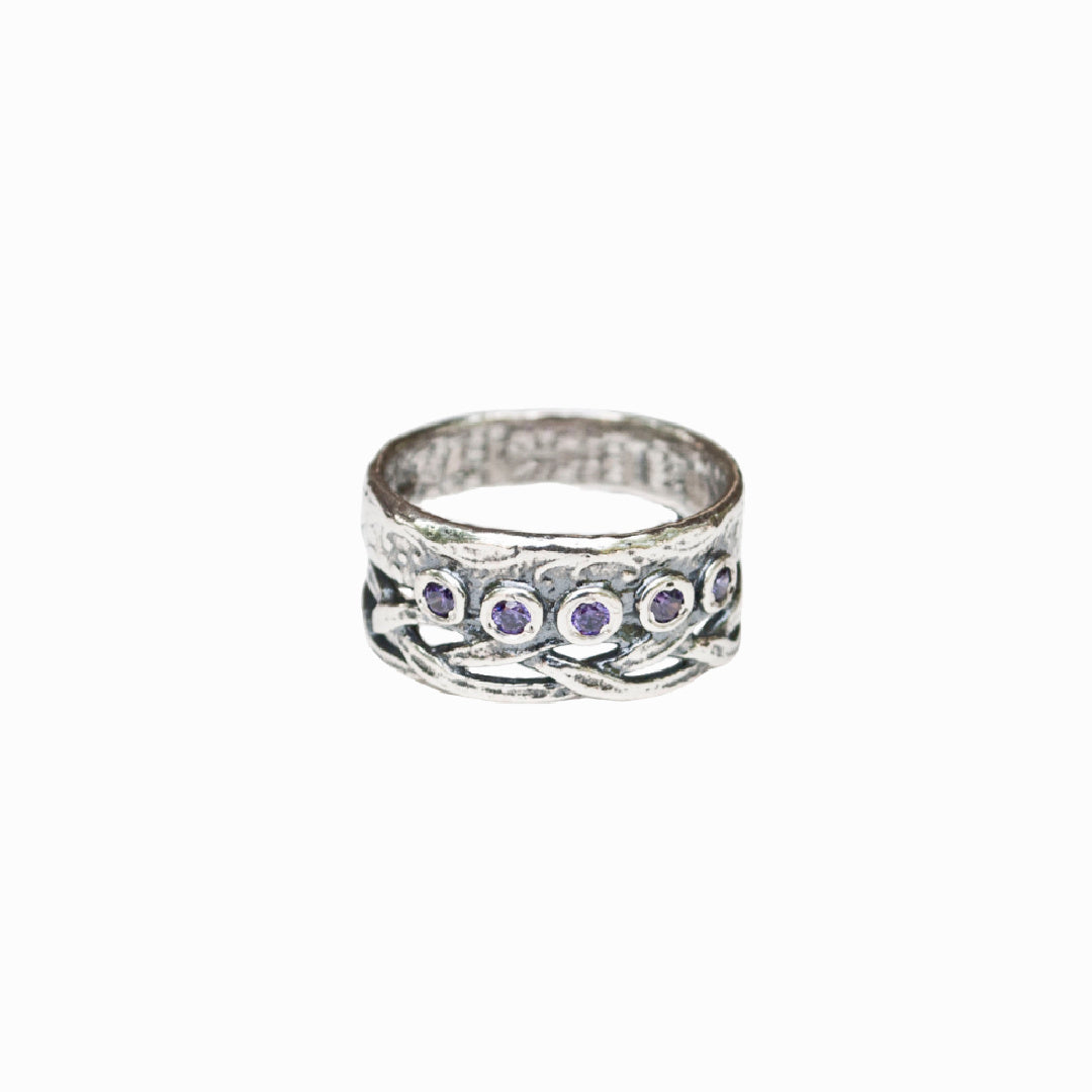 A sterling silver ring with a woven crown detail and bezel-set amethyst CZ stones. Shown on a white background. 