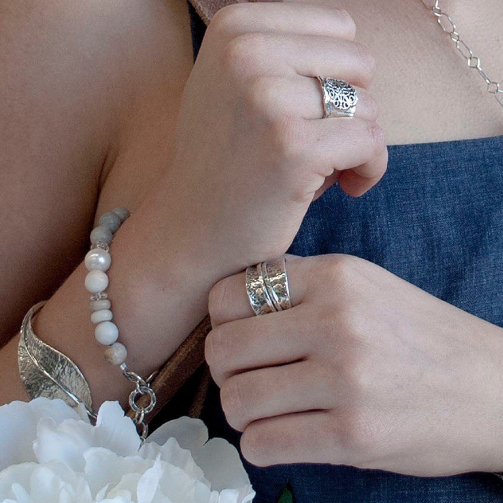 A ring with two spinning bands doubles the fun. This ring is artisan-crafted of .925 sterling silver, with a lightly oxidized, hammered finish and a tapered back for the most comfortable fit. Shown on a model.