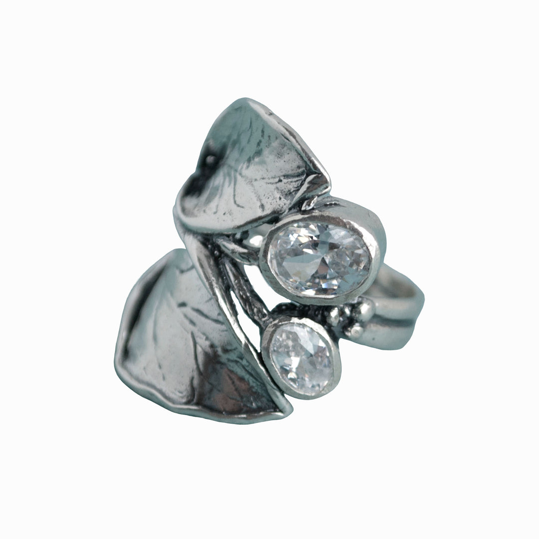 A sterling silver ring with a leaf design and two oval-shaped clear cubic zirconia stones. Shown on a white background. 