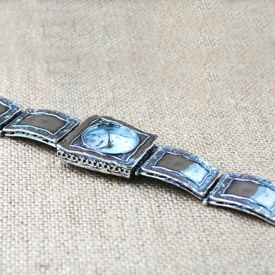 Silver Watch. .925 sterling Silver artisan crafted watch with mother of pearl face shown from the side. Highlighting the details.