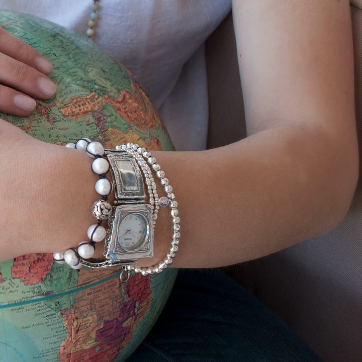 A.925 sterling silver artisan-crafted watch shown on a model with other bracelets. 