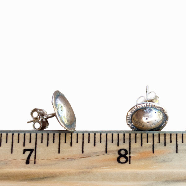 Round-textured sterling silver post earrings are shown next to a ruler for scale. 