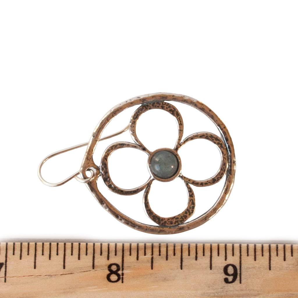 Round sterling silver earrings with a flower design and labradorite centers are shown with a ruler for size. 1 7/8" long