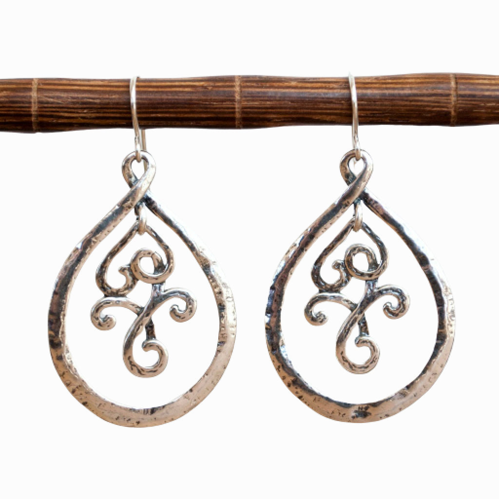 Silver Dangle Earrings- artisan crafted of .925 sterling silver dangle earrings with an inner scrolled part that creates great movement. Shown dangling from a wooden dowel on a white background.