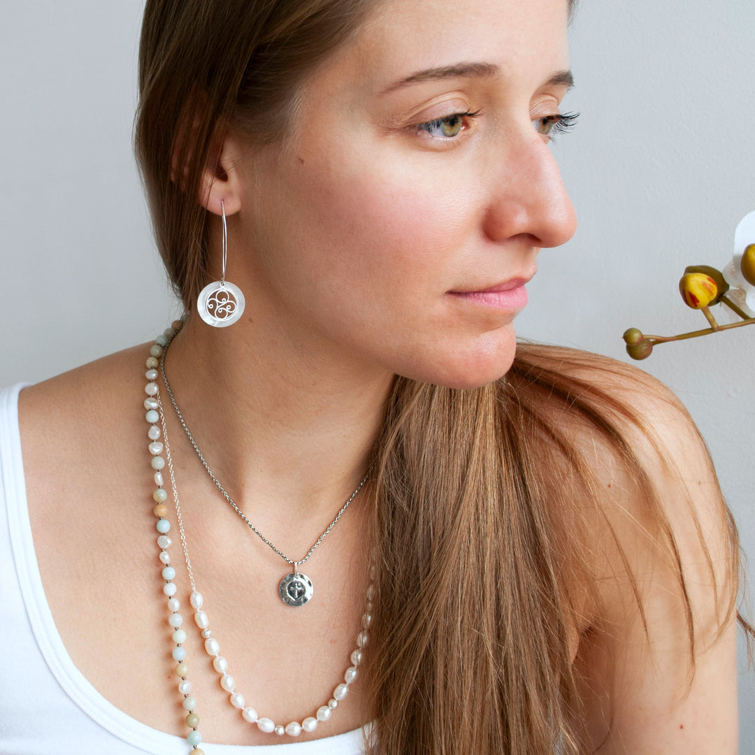Long Earrings with sterling silver filigree and mother of pearl. Shown on a model.