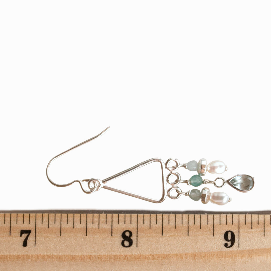 Earrings Sterling silver chandelier with drops of aquamarine, freshwater pearls and aqua chalcedony are shown with a ruler for size.