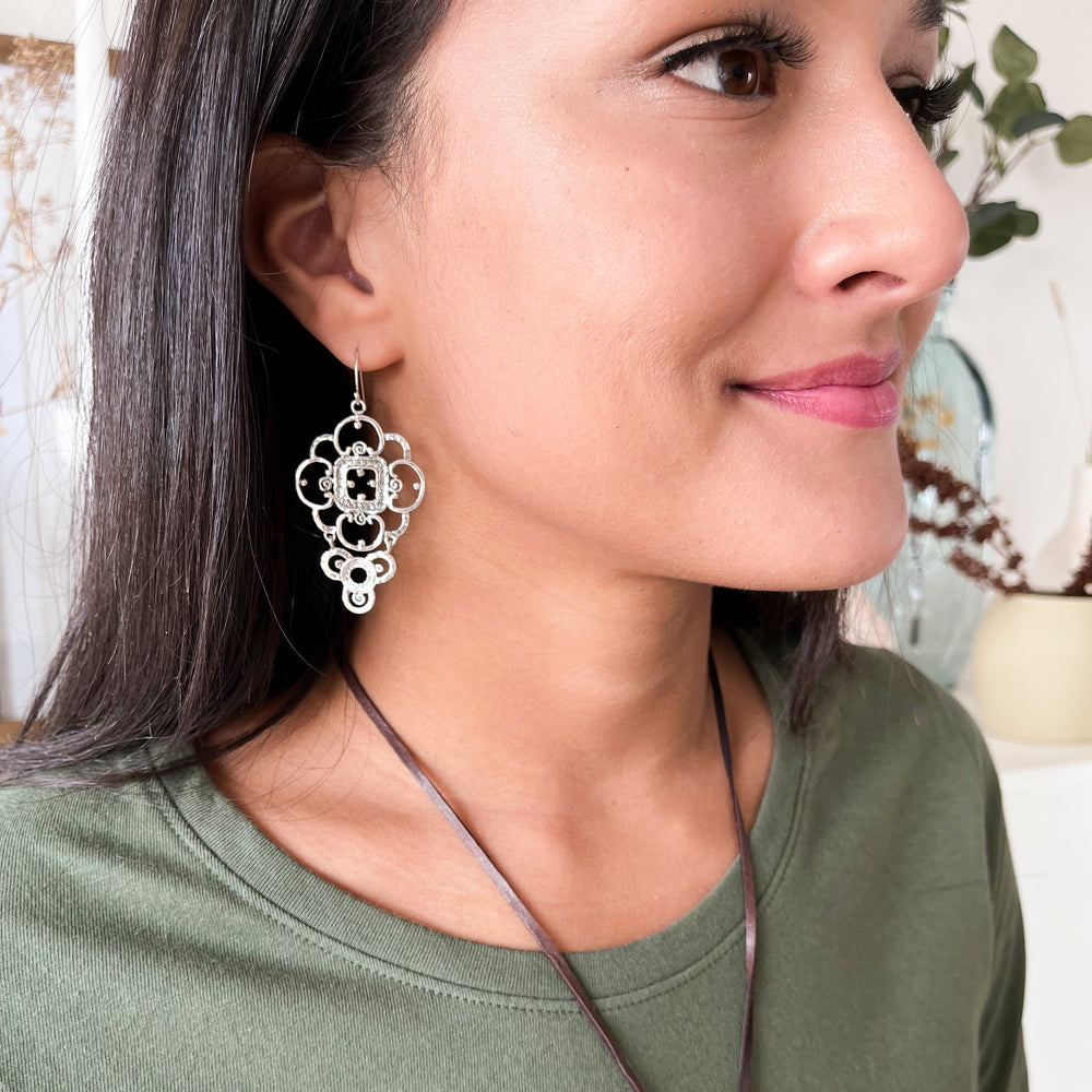 Sterling silver earrings with a lacey design. Shown on a model. 
