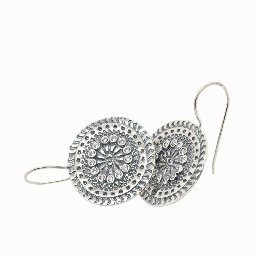 A pair of sterling silver mandala earrings with clear CZ stones, crafted with a .925 sterling silver quality stamp, displayed against a white background.