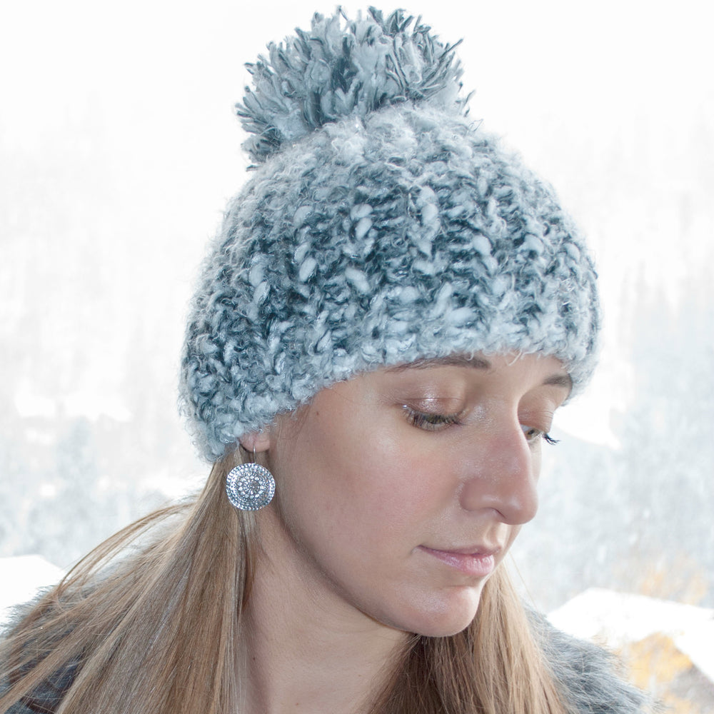 A pair of sterling silver mandala earrings with clear CZ stones, crafted with a .925 sterling silver quality stamp, shown on a model. 